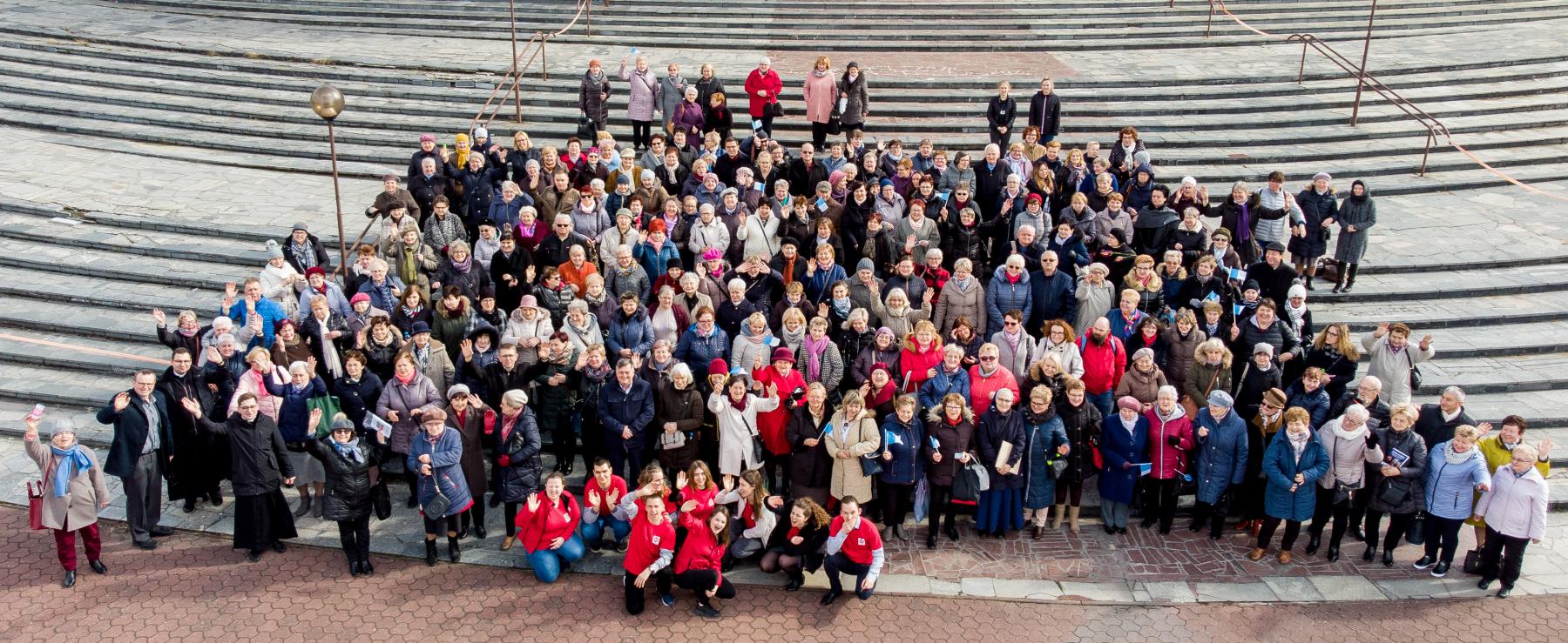 Kilkaset wolontariuszy Parafialnych Zespołów Caritas na schodach, zdjęcie grupowe z góry